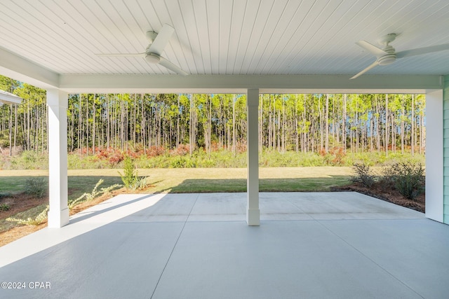 view of patio / terrace with ceiling fan and a forest view