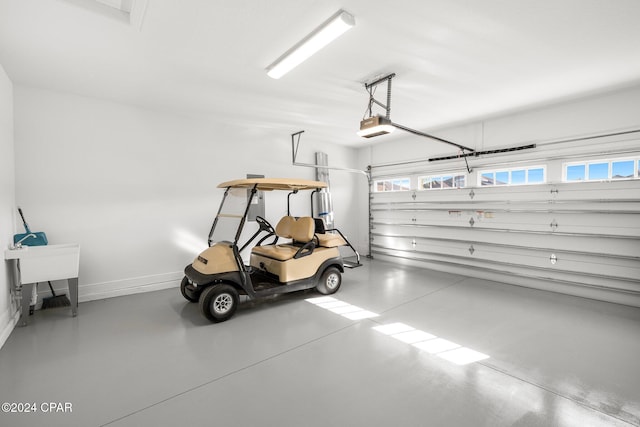 garage featuring a garage door opener and baseboards