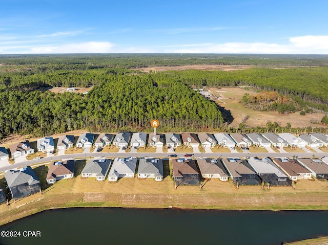 bird's eye view featuring a water view, a residential view, and a wooded view