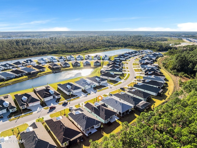 drone / aerial view featuring a residential view, a forest view, and a water view