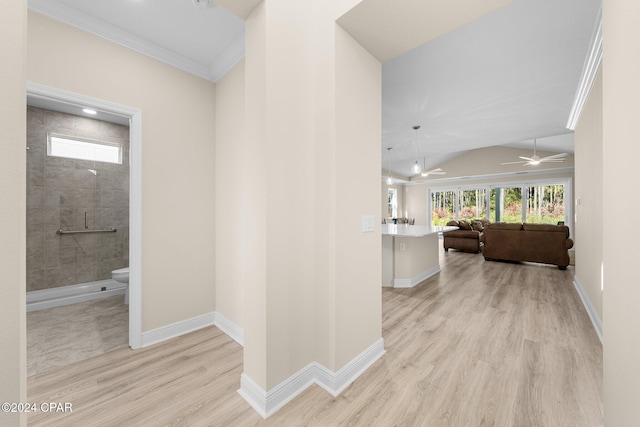 corridor with vaulted ceiling, crown molding, baseboards, and wood finished floors