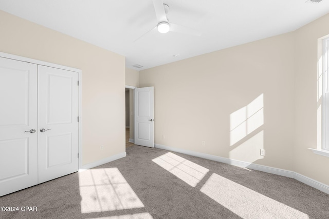 unfurnished bedroom with a closet, carpet flooring, and baseboards