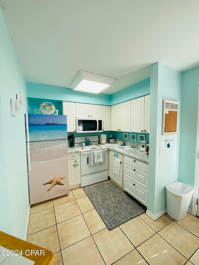 kitchen with white cabinets, light tile patterned floors, white appliances, and sink