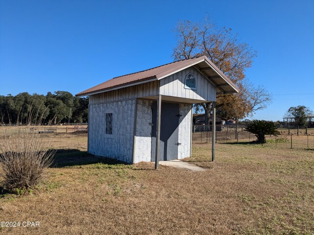 view of outdoor structure featuring a rural view and a yard