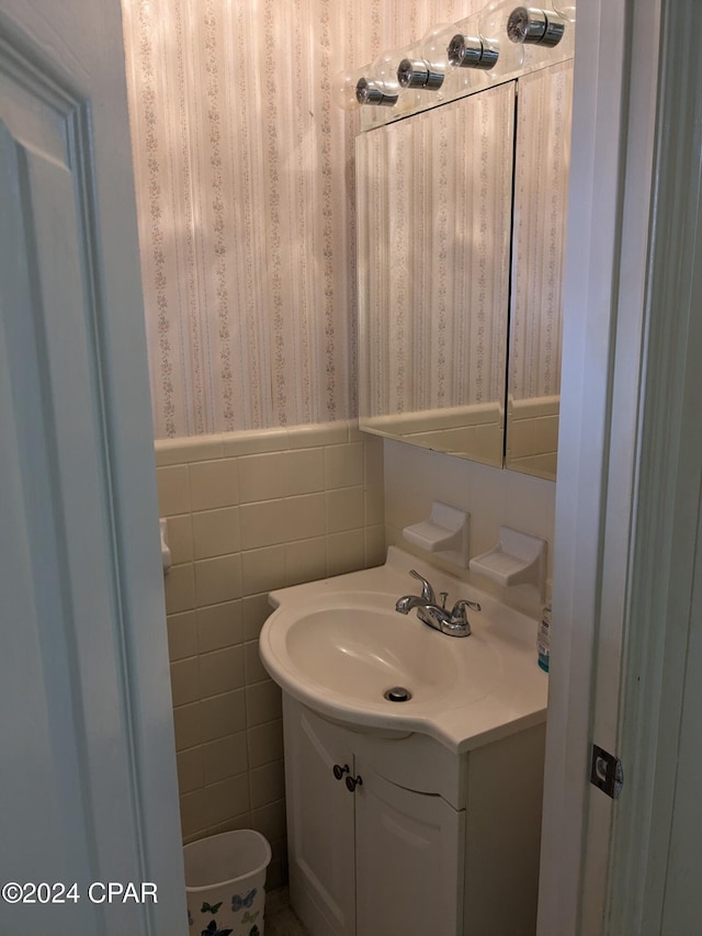 bathroom with vanity and tile walls