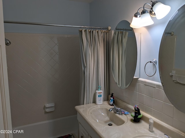 bathroom with decorative backsplash, shower / tub combo with curtain, and vanity