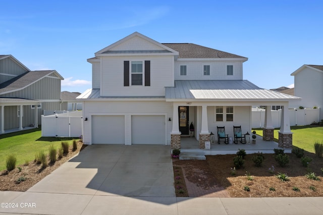 view of front of house with a porch, a garage, and a front yard