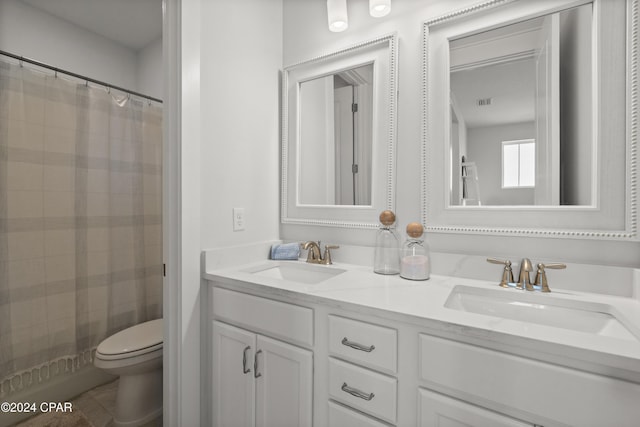 bathroom featuring toilet, vanity, and walk in shower