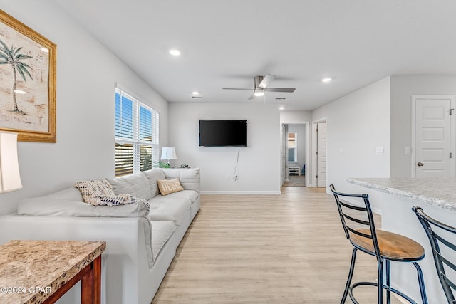 living room featuring light hardwood / wood-style floors and ceiling fan