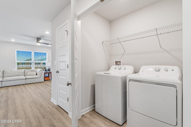 laundry area with ceiling fan, washing machine and dryer, and light hardwood / wood-style flooring