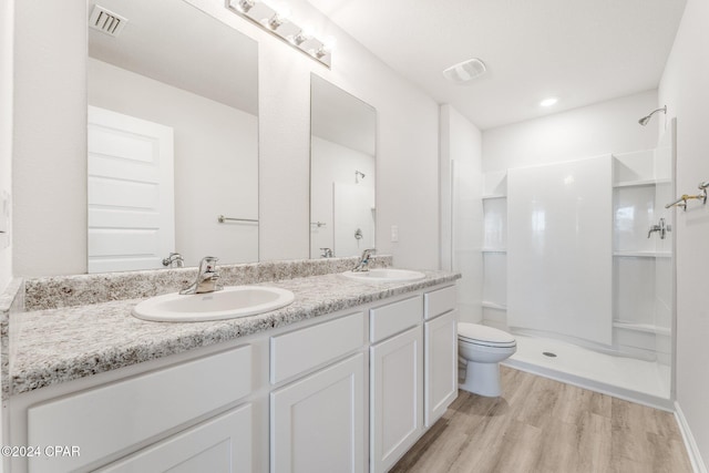 bathroom featuring a shower, toilet, vanity, and hardwood / wood-style flooring