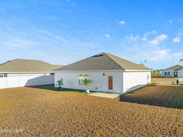 rear view of house featuring a patio area and a yard