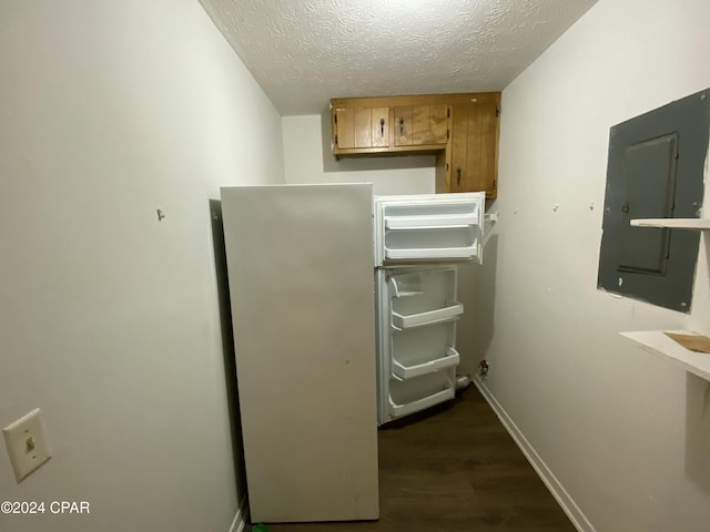 kitchen with dark hardwood / wood-style floors, a textured ceiling, and electric panel