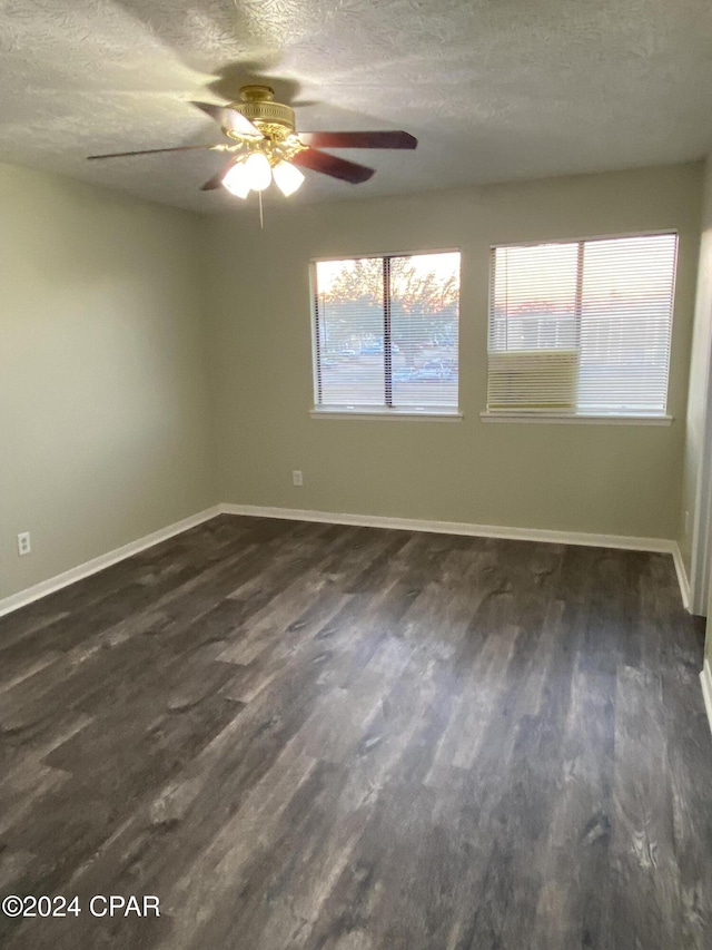 unfurnished room with a textured ceiling, dark hardwood / wood-style flooring, and ceiling fan