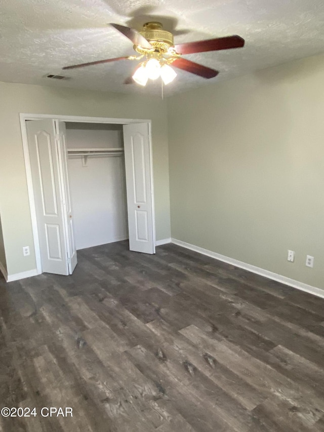 unfurnished bedroom with dark hardwood / wood-style flooring, a textured ceiling, a closet, and ceiling fan