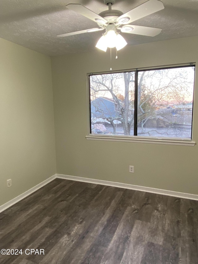 spare room with a textured ceiling, dark hardwood / wood-style flooring, and ceiling fan