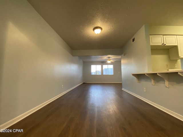 spare room featuring ceiling fan, a textured ceiling, and dark wood-type flooring