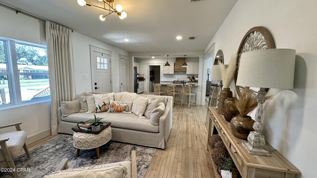 living room featuring a chandelier and light hardwood / wood-style floors