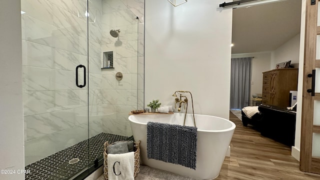 bathroom with separate shower and tub and wood-type flooring