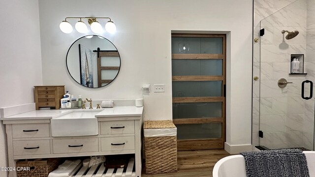 bathroom with hardwood / wood-style floors, vanity, and a shower with shower door