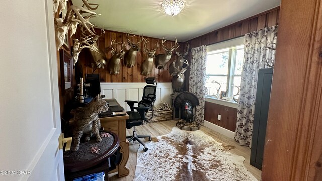 home office featuring wood walls and light hardwood / wood-style flooring