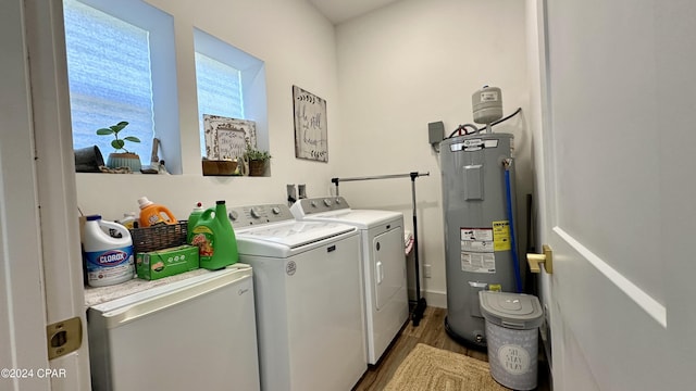 clothes washing area featuring separate washer and dryer, water heater, and light hardwood / wood-style flooring