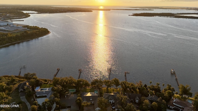 aerial view at dusk featuring a water view