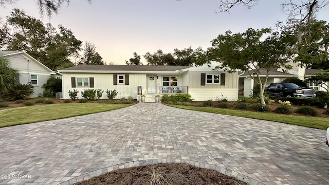 single story home with a yard and a porch