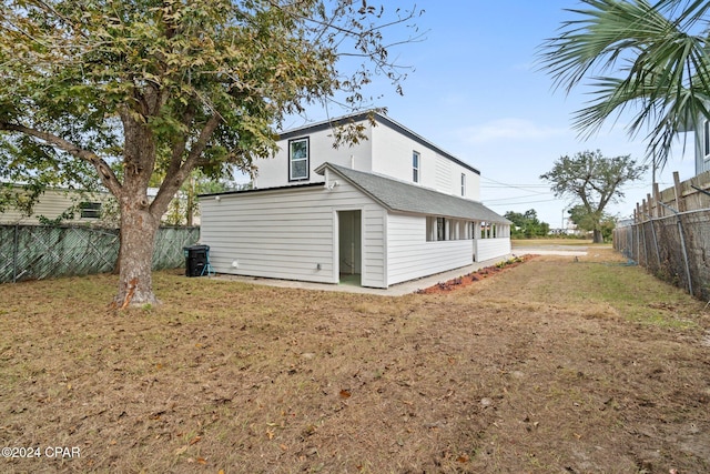 rear view of property featuring a lawn