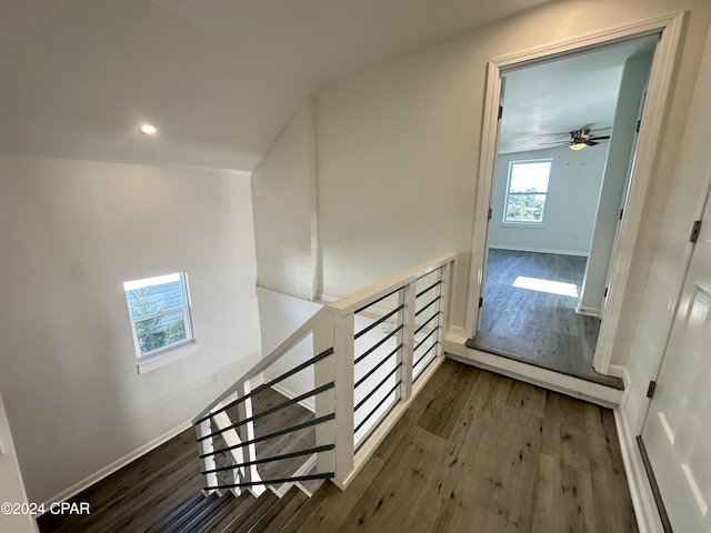 stairs with hardwood / wood-style floors, ceiling fan, and vaulted ceiling