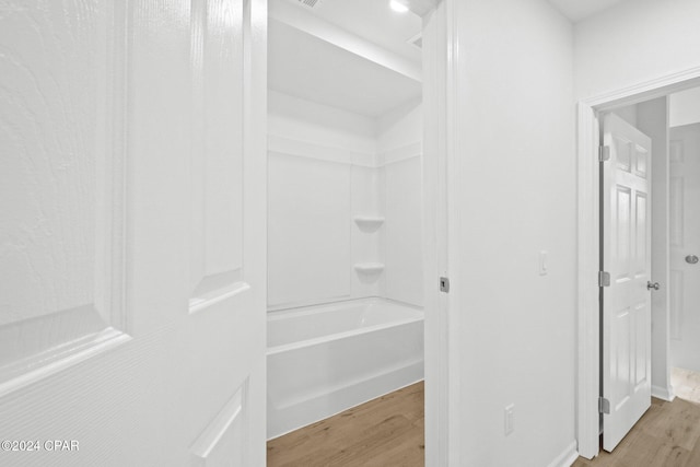 bathroom with hardwood / wood-style floors and  shower combination