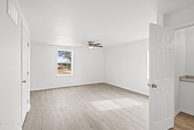 empty room with ceiling fan and light wood-type flooring