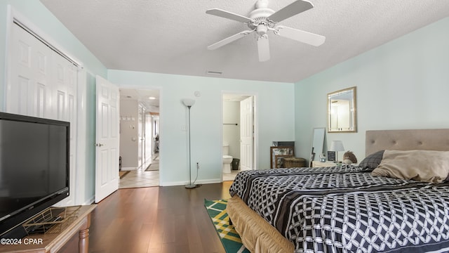 bedroom featuring ensuite bath, wood-type flooring, a textured ceiling, and ceiling fan