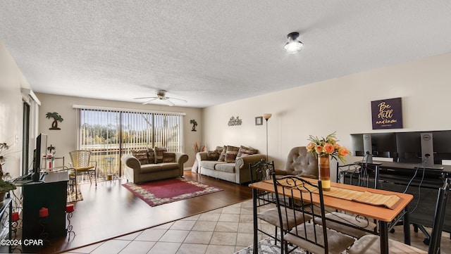 living room with tile patterned flooring, ceiling fan, and a textured ceiling