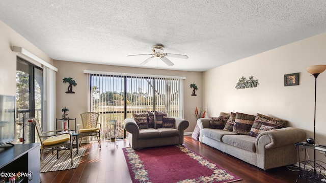 living room with ceiling fan, dark hardwood / wood-style floors, and a textured ceiling