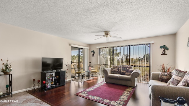 living room featuring hardwood / wood-style flooring, ceiling fan, and a textured ceiling