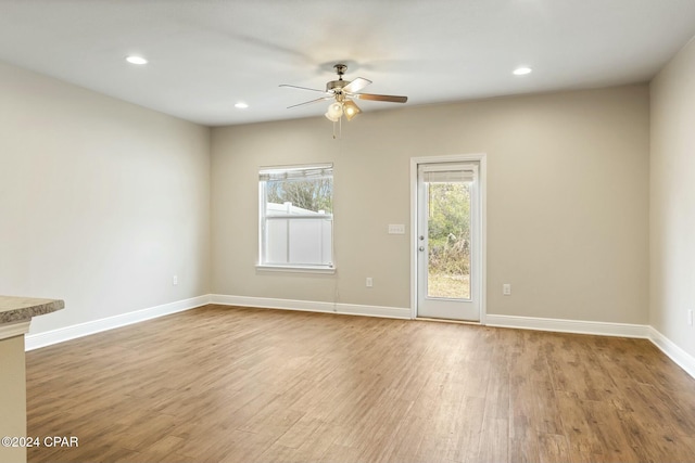 unfurnished room with light wood-type flooring, plenty of natural light, and ceiling fan