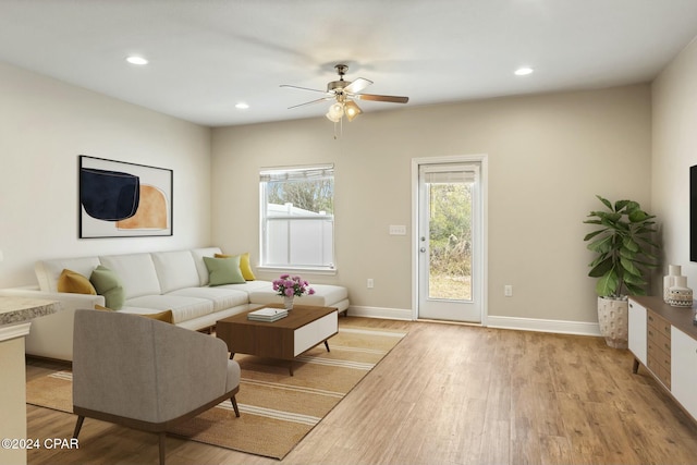 living room with light hardwood / wood-style floors, plenty of natural light, and ceiling fan