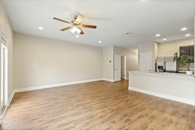 unfurnished living room with light wood-type flooring and ceiling fan