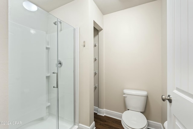 bathroom featuring toilet, wood-type flooring, and walk in shower