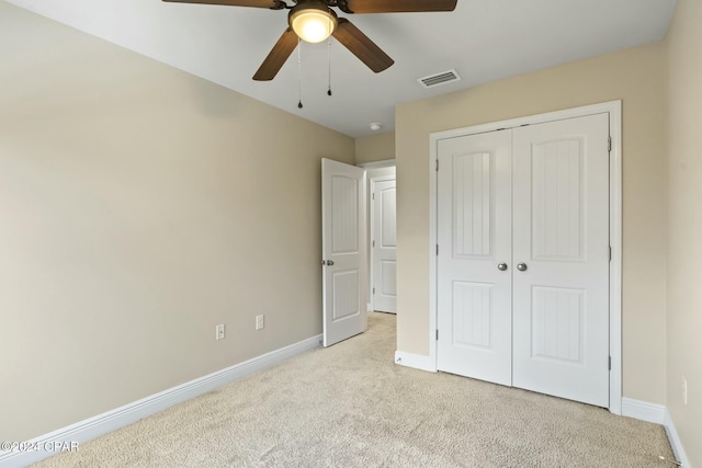 unfurnished bedroom with a closet, ceiling fan, and light colored carpet