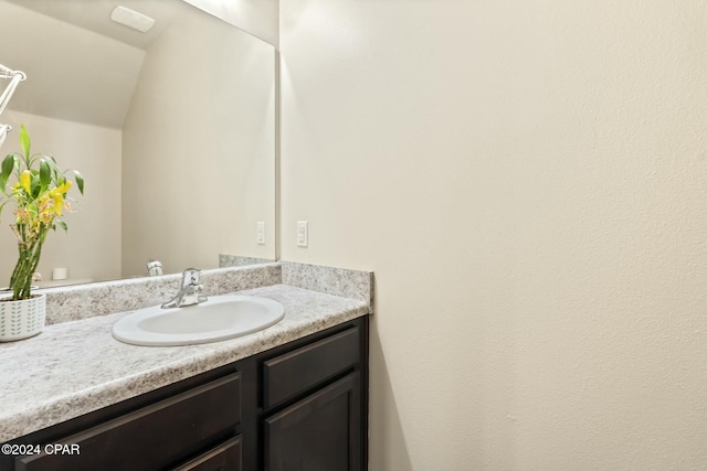 bathroom featuring vanity and lofted ceiling