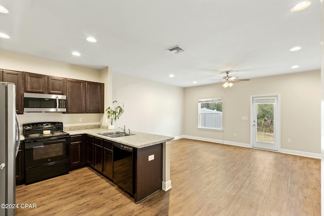 kitchen with black appliances, sink, ceiling fan, light wood-type flooring, and kitchen peninsula