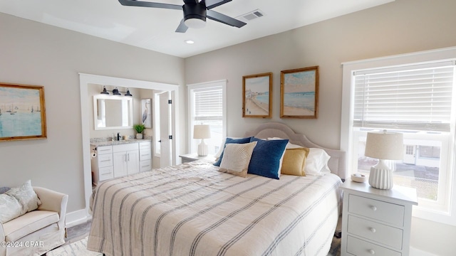 bedroom with ceiling fan, sink, light hardwood / wood-style flooring, and multiple windows