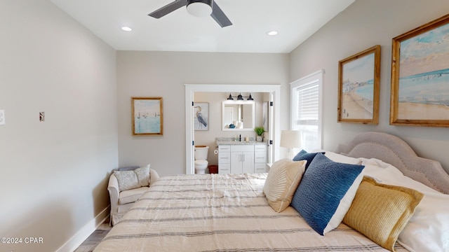 bedroom with wood-type flooring, ensuite bathroom, ceiling fan, and sink