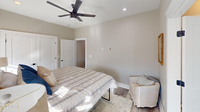 bedroom with ceiling fan, wood-type flooring, and a closet