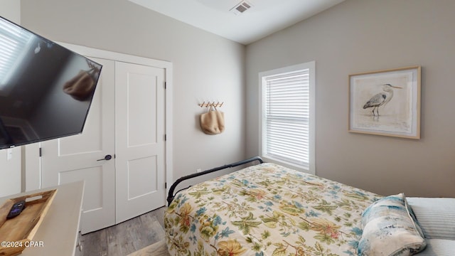 bedroom with light hardwood / wood-style flooring and a closet