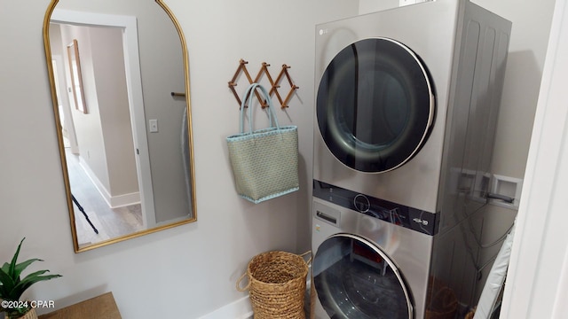 washroom with wood-type flooring and stacked washer and clothes dryer