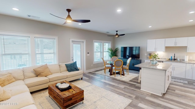 living room with ceiling fan and light hardwood / wood-style flooring