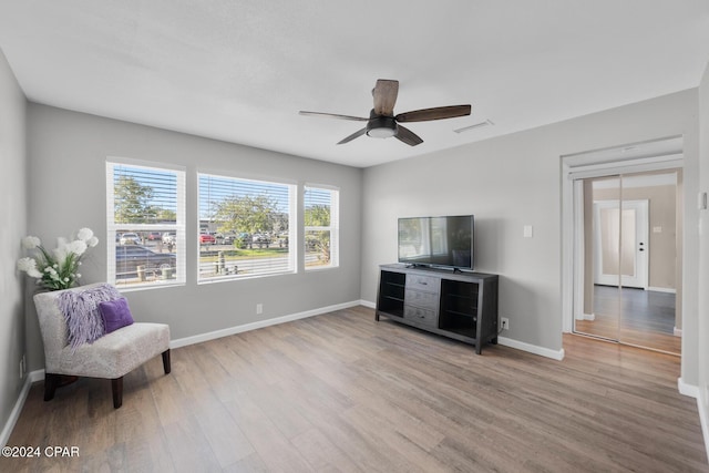 living area with ceiling fan and wood-type flooring